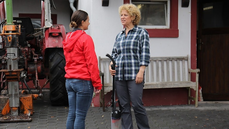 Jenny und Bea stehen hinter Karls Traktor