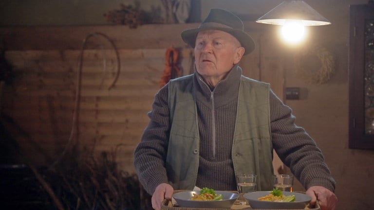 Josef Zimmermann mit zwei mit Risotto gefüllten Tellern in seinem Brennkeller