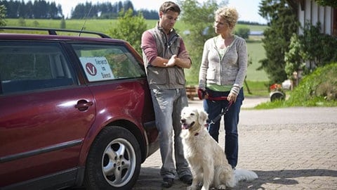 Andreas und Bea stehen mit Hofhund Willy an Andrea's Auto vor dem Fallerhof