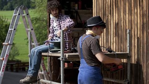 Albert und Sebastian schleifen ein großes Holztor ab