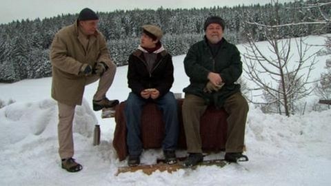 Heinz, Daniel und Hermann auf einer Bank im Schnee