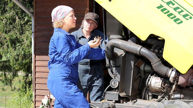 Evelyn und Bea stehen vor Karls Siliermaschine