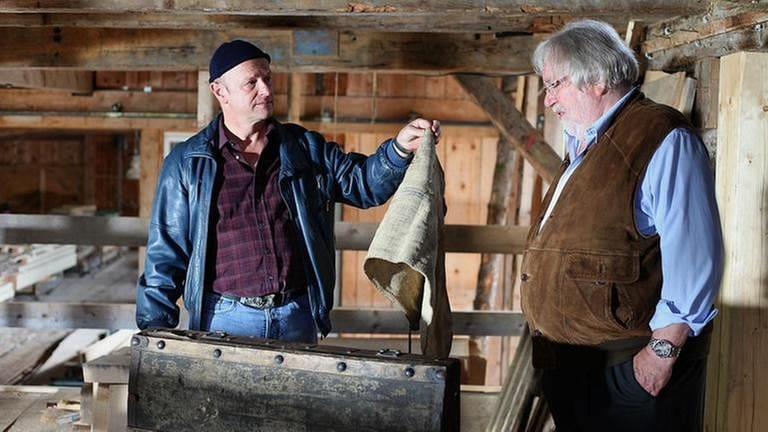 Toni hält Hermann in der Mühle einen alten Lappen hin