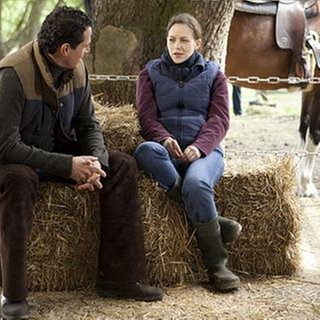 Matthias und Sophie sitzen auf Heuballen vor den Pferdeställen