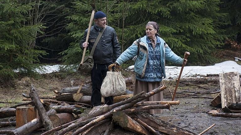 Toni und Lioba vor einem Scheiterhaufen im Wald