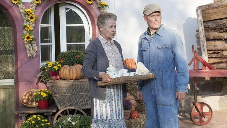 Johanna und Karl stehen mit erschrockenem Gesichtsausdruck vor Johannas Hofladen