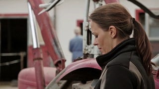 Sophie steht traurig neben Karls Traktor