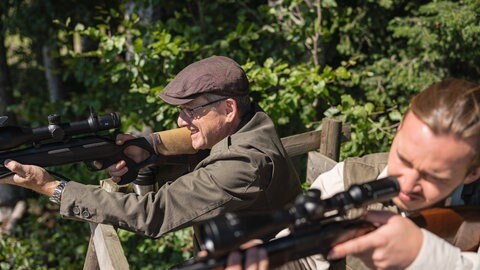 Bernhard und Sebastian mit angelegten Gewehren auf dem Hochsitz