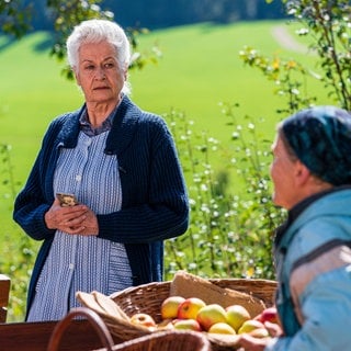 Johanna und Lioba mit Obstkörben hinterm Hofladen