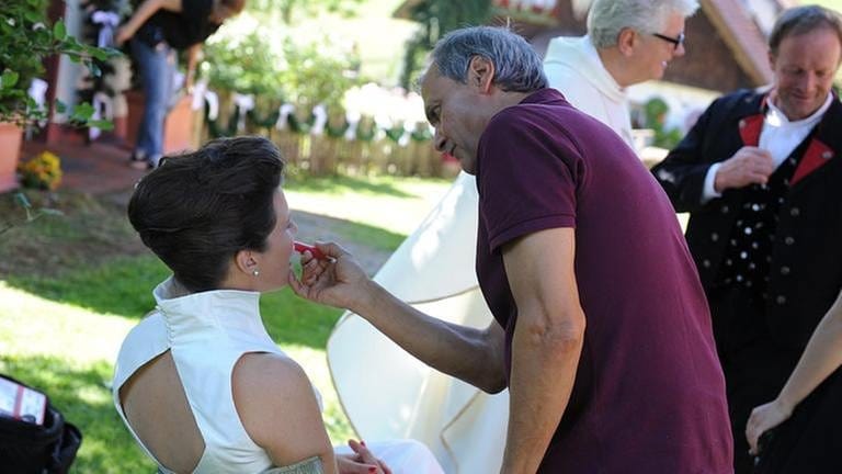 Maskenbildner schminkt Schauspielerin