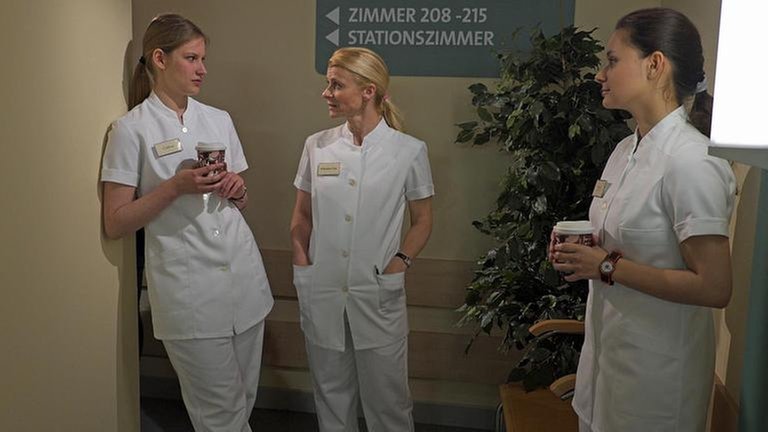 Celine, Caro und Jenny stehen auf dem Krankenhausflur und machen Pause