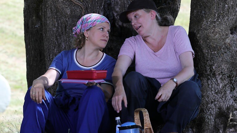 Bea und Evelyn machen Pause unter einem Baum 