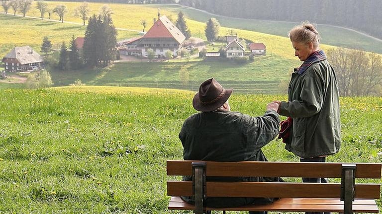 Hermann und Johanna an einer Bank mit Blick auf den Fallerhof.