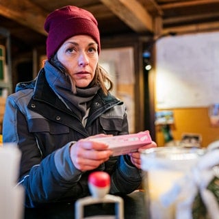 Sophie (Janina Flieger) sitzt in ihrem Büro und hat einen Schwangerschaftstest in der Hand