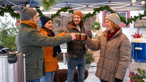 Die Fallers stoßen beim Adventsbazar mit Glühwein an