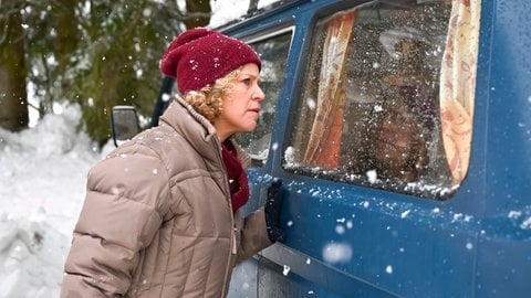 Bea (Christiane Brammer) guckt in einen Blauen Wagen