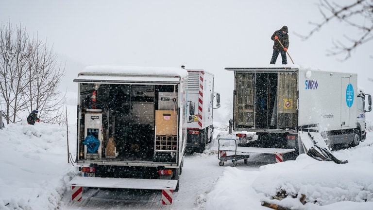 Teammitglied befreit LKW-Dach von Schnee