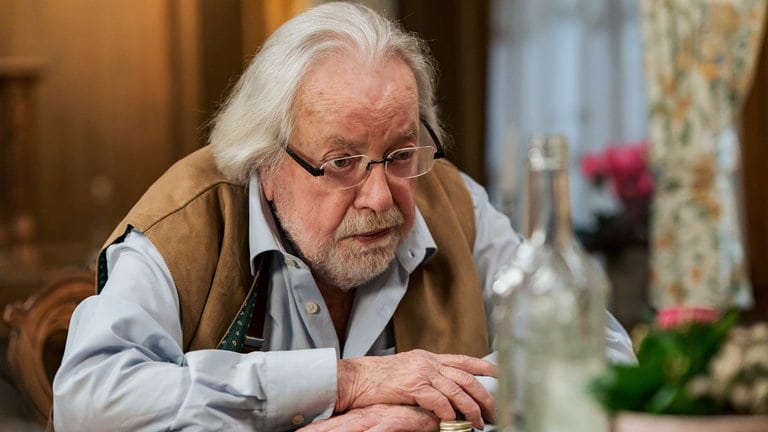 Hermann (Wolfgang Hepp) sitzt vor einer Schnapsflasche