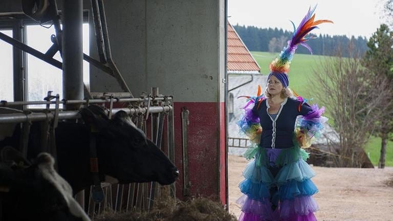 Bea steht im üppigen Faschingskostüm im Kuhstall