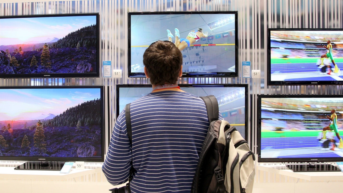 Ein Journalist betrachtet auf der IFA in Berlin in den Messehallen unter dem Funkturm Fernsehgeräte. Die Änderungen 2024 beim Kabelfernsehen in Deutschland sind vor allem für Mieter interessant.