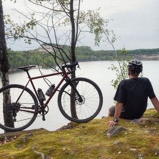 Mann mit Fahrrad am See - Radtour 