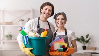 Mann und Frau mit Putzmitteln und Reinigunstextilien