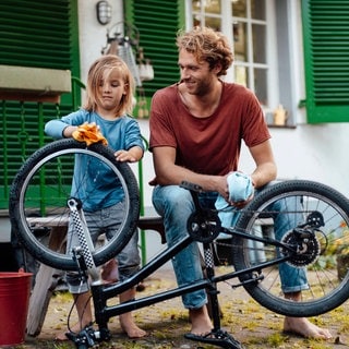 Vater und Sohn putzen Fahrrad