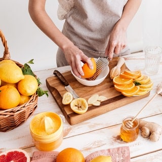 Frau drückt Grapefruit und Orangen aus