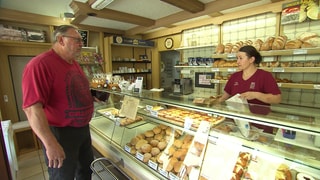 Eine Frau bedient einen Kunden an der Bäckereitheke der traditionsreichen Bäckerei Gönninger in Glems.