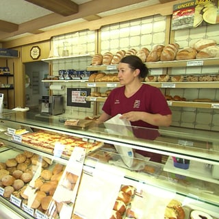 Eine Frau bedient einen Kunden an der Bäckereitheke der traditionsreichen Bäckerei Gönninger in Glems.