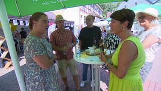 Landesschau-Reporterin Sonja Faber-Schrecklein steht beim Dörflefest in Widdern. Dort spricht sie mit mehreren Bürgern.