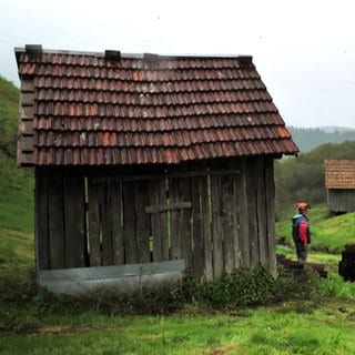 Ein Mann steht vor einer Heuhütte im Murgtal