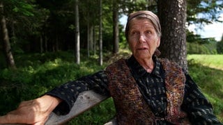 30 Jahre Fallers - Kräuterfrau Lioba Weber sitzt auf einer Bank im Wald