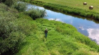 Donau-Experte Walter Knittel von Donaubergland GmbH läuft über eine Wiese zur Donau