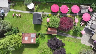 Das Gartencafé mit Sonnenschirmen aus der Luft