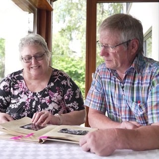 Frau und Mann blättern in einem Buch