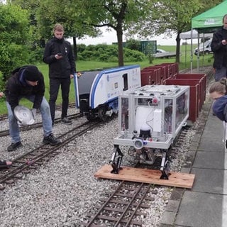 Mehrere Personen testen ihre selbstgebaute Lok