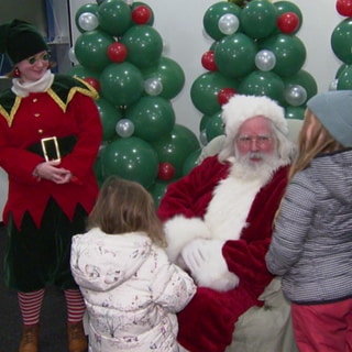 Weihnachtsmann spricht mit Kindern