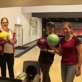 Junge Menschen spielen zusammen Bowling