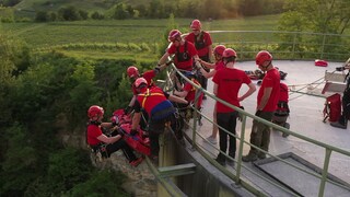 Leute der Bergwacht seilen sich von einem Turm ab. 