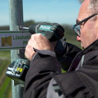 Karl Küchle repariert ein Schild in den Weinbergen am Kaiserstuhl