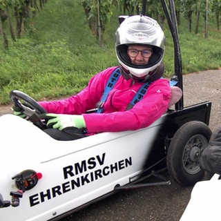 Zwei Frauen sitzen mit Helm in zwei weißen Wägen 