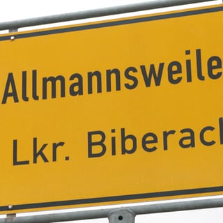 Großaufnahme gelbes Stadtschild mit Aufschrift "mann"