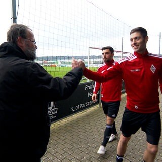 Fußballfan klatscht Spieler ab. Ein Herz für den Amateurfußball: Claus "Bredi" Breitenberger ist jedes Wochenende auf vielen Sportplätzen in Ostwürttemberg unterwegs.