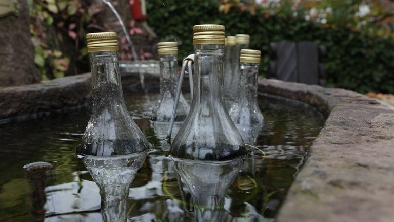 Glasflaschen in Wasser in Schnapsbrunnen