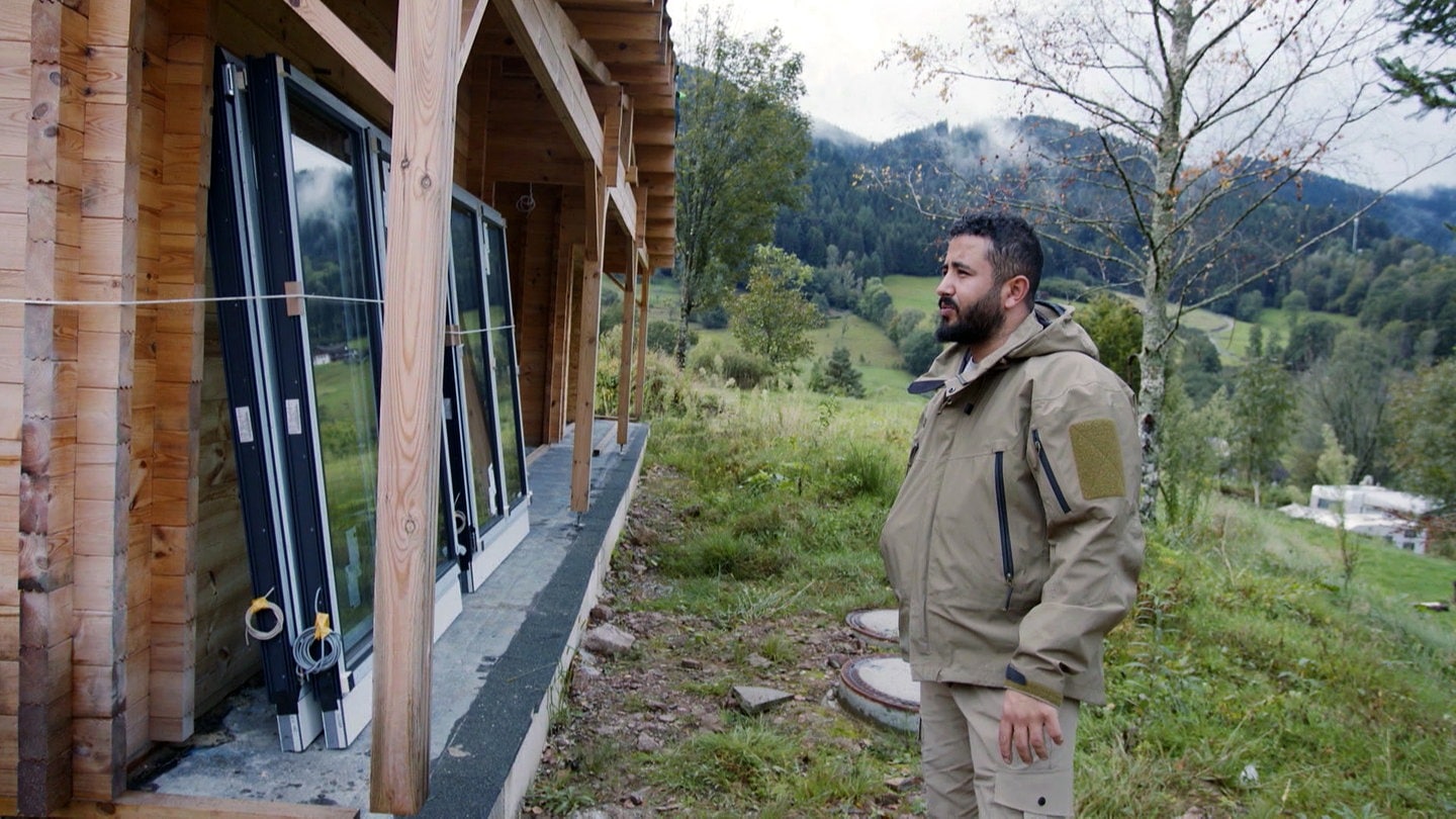 Betab steht vor einem Ferienhäuschen, das auf dem Campingplatz in Wolfach im Schwarzwald neu gebaut wird.