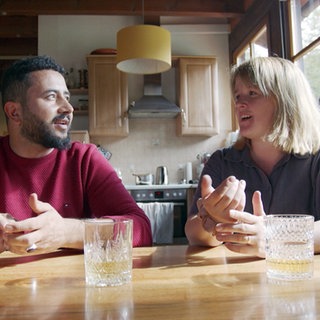 Betab und Michelle sind die neuen Betreiber des Campingplatzes in Wolfach. Sie sitzen am Tisch und unterhalten sich.