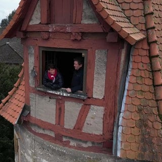 Sonja lehnt am Fenster eines alten Turms