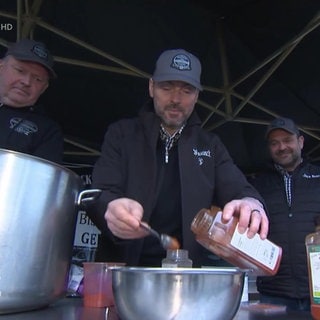 Vier Männer machen Barbecue-Soße