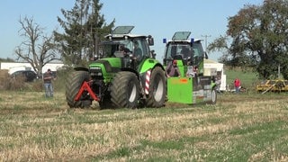 Ein Traktor zieht einen Bremswagen über einen Acker